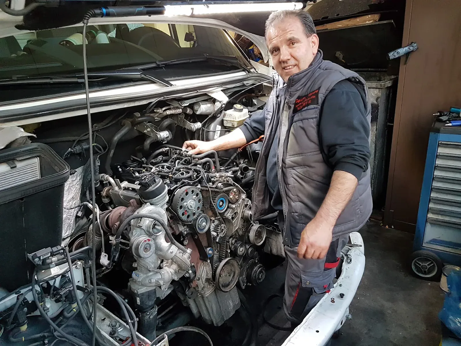 Mitarbeiter der Garage Europa bei der Arbeit an einem geöffneten Motorraum